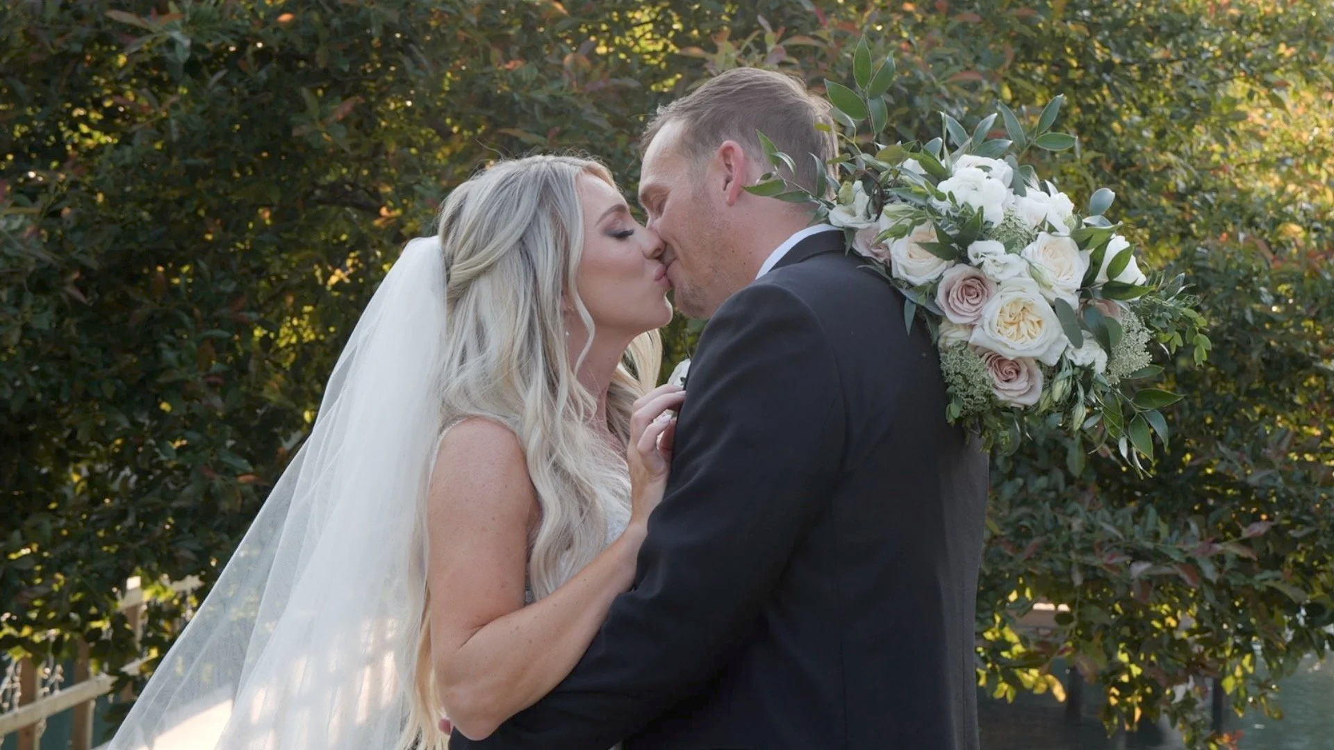 Cinematic black-and-white still of Emily and Chris embracing on their Raleigh wedding day, filmed by Lucas Studios NC.