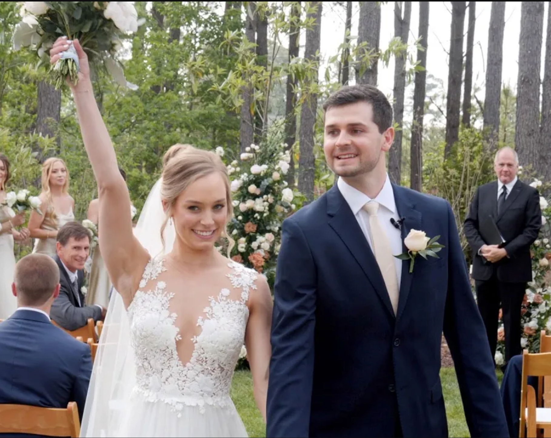 A bride and groom celebrating together at the end of the aisle after their wedding ceremony.